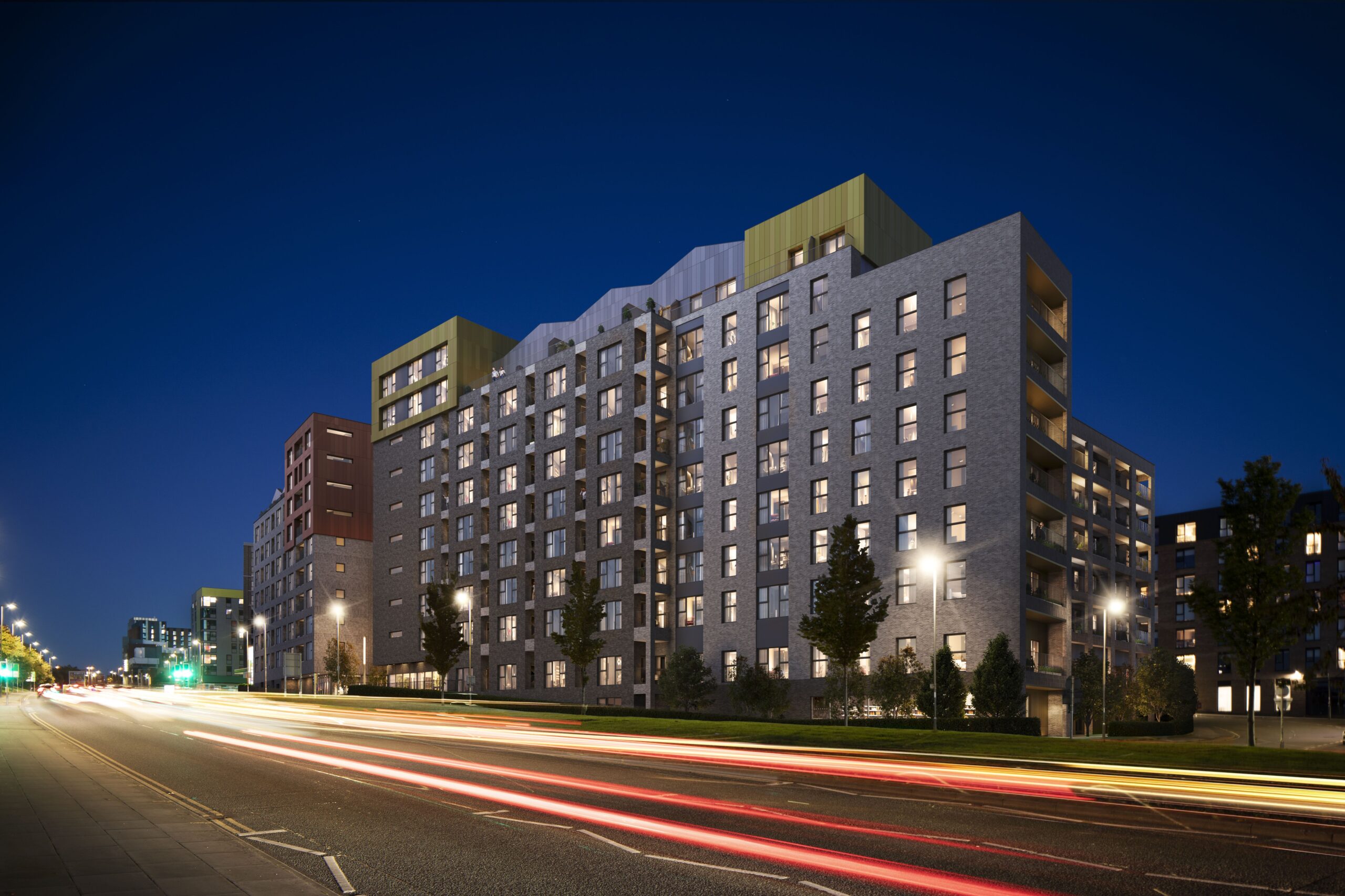 Night-time architectural CGI of a modern residential development in Liverpool beside a city road, with illuminated apartments and traffic light trails.